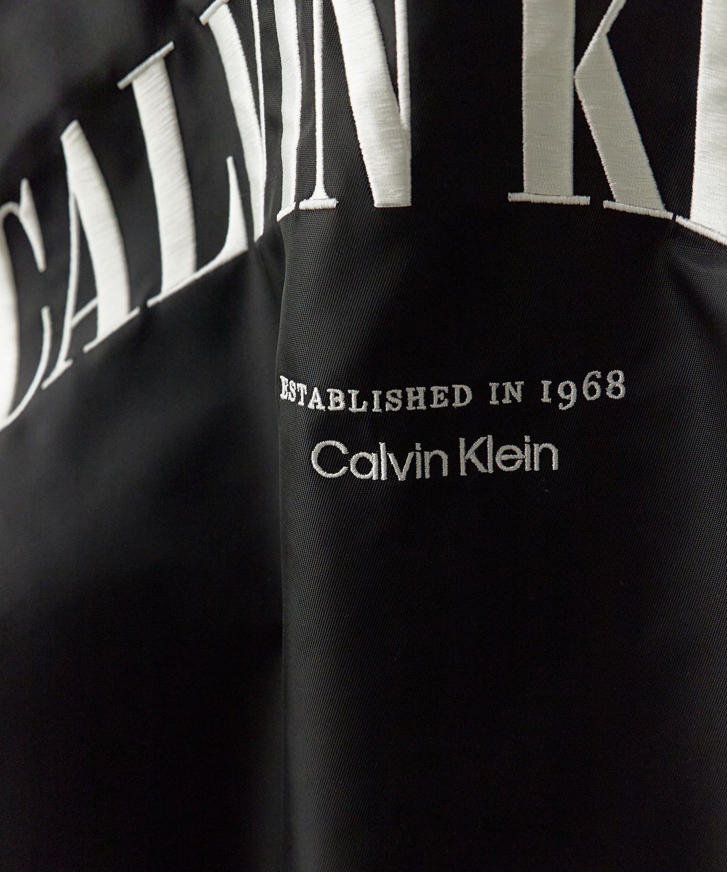Calvin Klein / LSUNFILLED NYLON TIPPED GRAPHIC BOMBER JUNG KOOK /