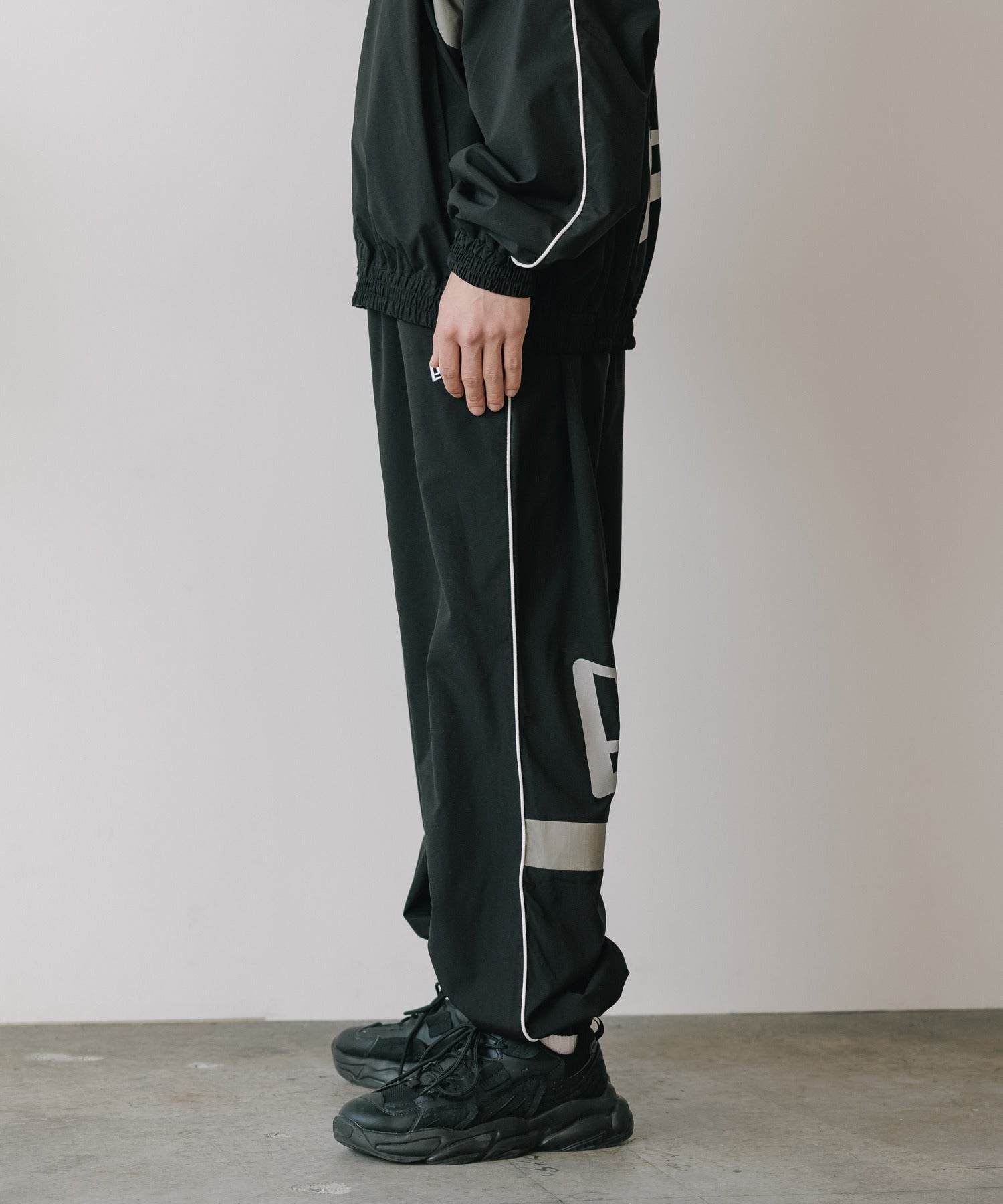 CALEE × NEW ERA/ CALEE LOGO OVERSIZED PIPING TRACK PANTS