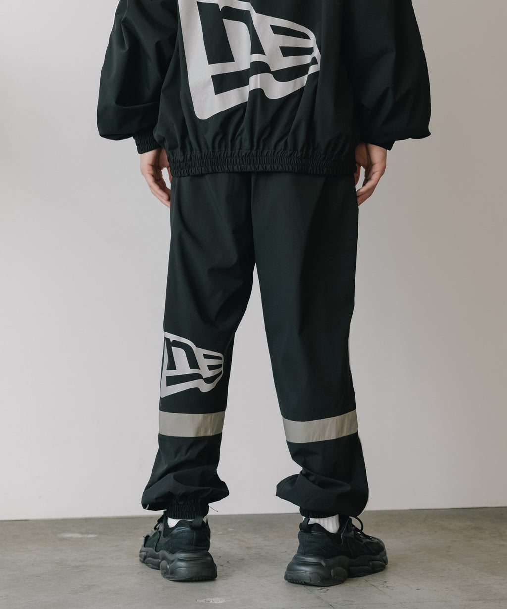 CALEE × NEW ERA/ CALEE LOGO OVERSIZED PIPING TRACK PANTS